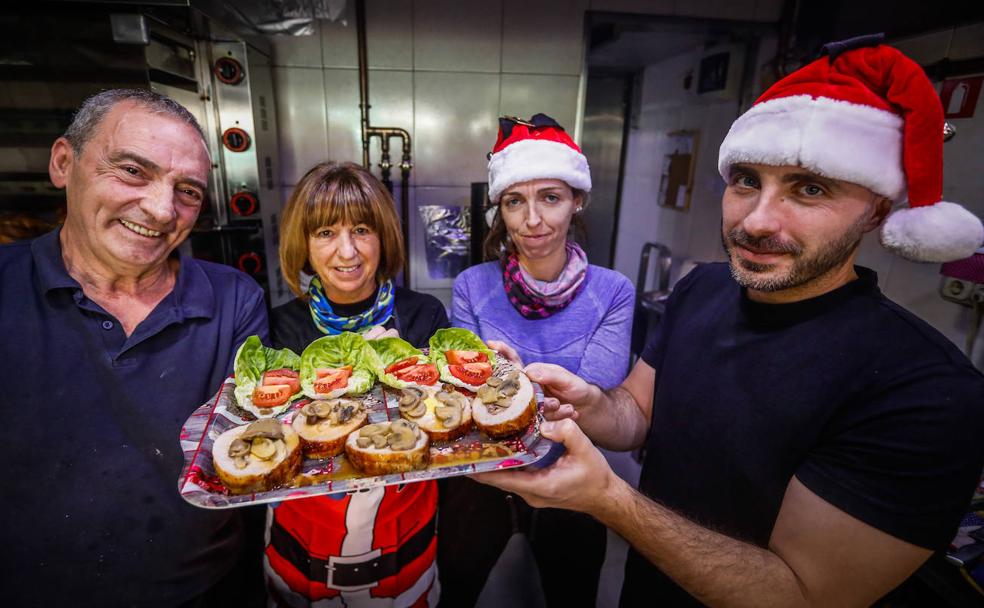 Los trabajadores de Asadero Rubén posan con una de sus recetas para esta Navidad./Ramón L. Pérez